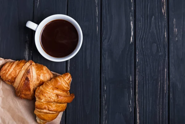 Café y croissants en la mesa negra — Foto de Stock