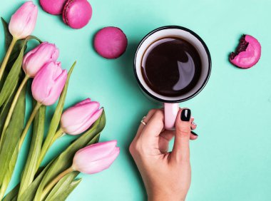 Kadının el holding Kupası kahve ve Pembe Lale ile