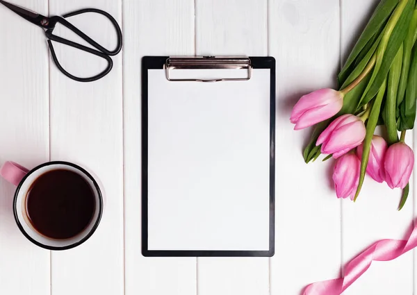 Attrappe mit leerem Papier, rosa Tulpen und Kaffee auf dem weißen Teppich — Stockfoto