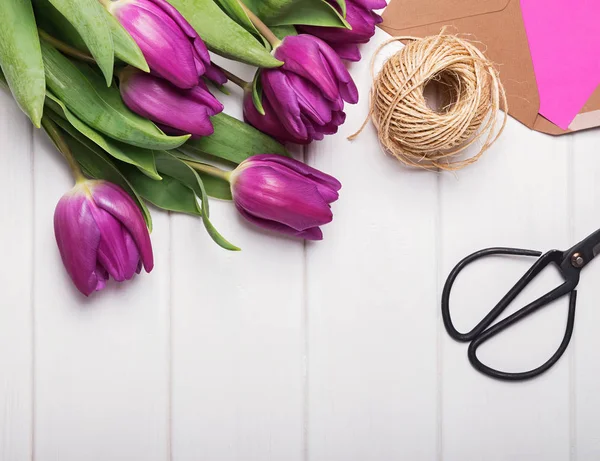 Paarse tulpen, schaar en jute touw op de witte houten tafel — Stockfoto