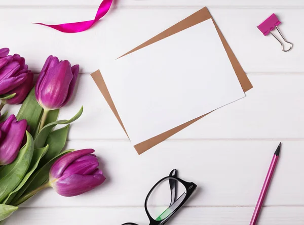 Empty paper mock-up on the table with purple tulips — Stock Photo, Image