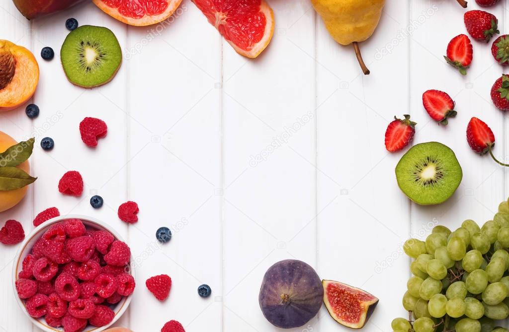 Fruits and berries on the white wooden background