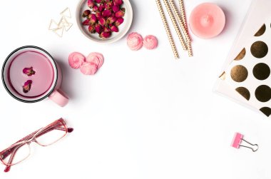 Masanın üzerine pembe ve altın renkli nesneleri.