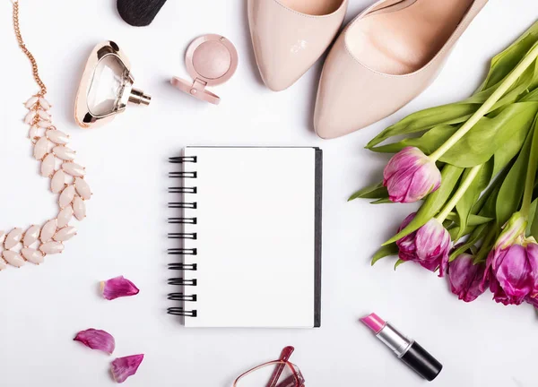 Stijlvolle vrouwelijke accessoires en blanco papier notepad — Stockfoto