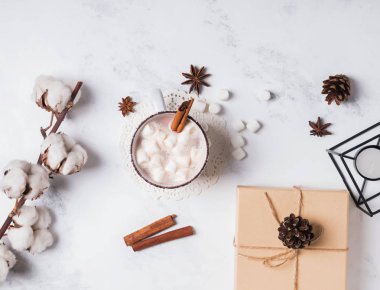 Mermer zemin üzerine sıcak kakao, pamuk şube ve çam kozalakları,