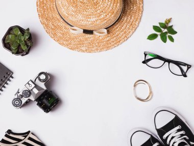 Hasır şapka, spor ayakkabıları, vintage fotoğraf makinesi ve diğer kıyafeti üzerinde beyaz ba
