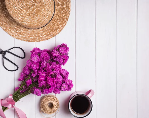 Květiny, klobouk a kávy na bílém pozadí dřevěná — Stock fotografie