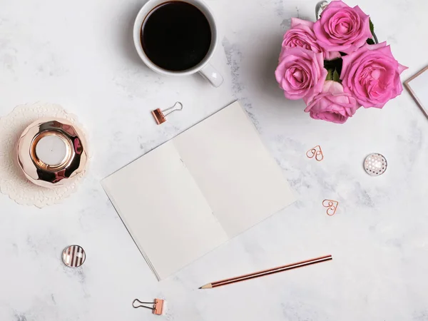 Kaffe, blommor, guld färgade pappersvaror och tomt anteckningsblock, topp — Stockfoto