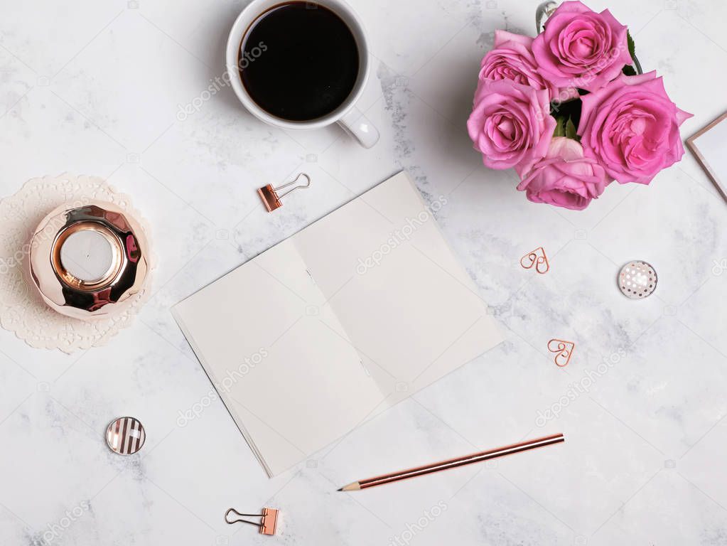 Coffee, flowers, gold colored stationery and blank notepad, top 