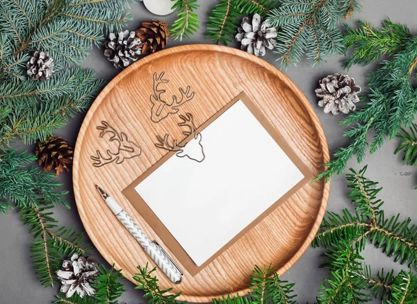 Noel kartı mock-up çam dalları ile ahşap plaka üzerinde