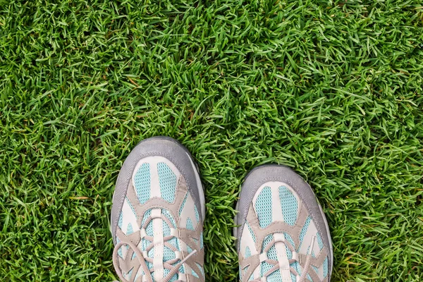Oude reizen sneakers op het groene gras — Stockfoto
