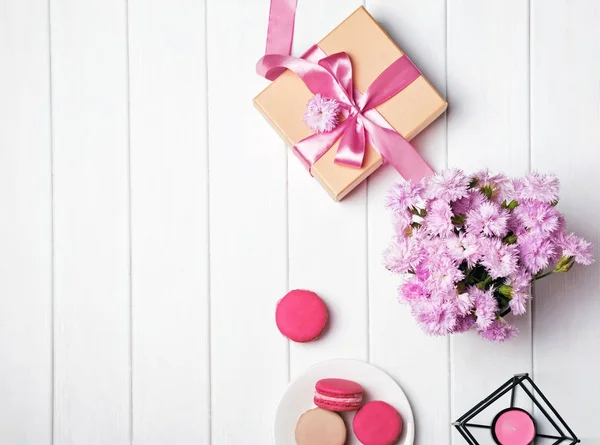 Roze bloemen en geschenkdoos met roze lint — Stockfoto