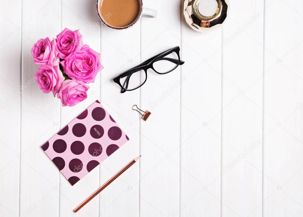 Stylish desk. Coffee, flowers, glasses and other accessories 