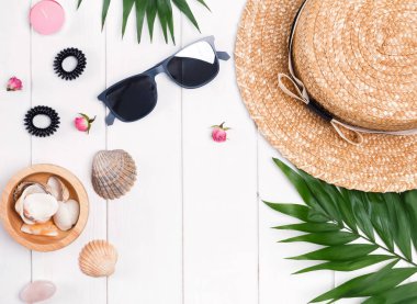 Hasır şapka, güneş gözlüğü, palmiye yaprakları ve kadınsı ac ile düz yatıyordu