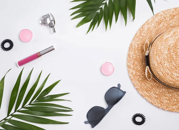 Cappello di paglia, occhiali da sole e foglie di palma sullo sfondo bianco . — Foto Stock