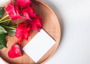 Boş kart, kırmızı gül ve kalp şeklinde mum ahşap plat