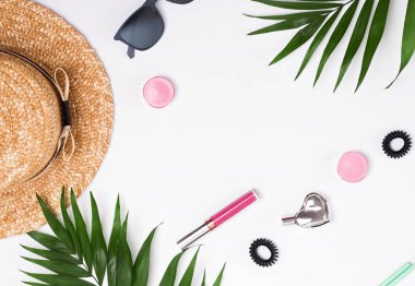 Yaz kadınsı aksesuarları ve yeşil yaprakları üzerinde beyaz backgr