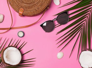 Kadınsı tatil aksesuarları üzerinde pembe bir arka plan, üstten görünüm