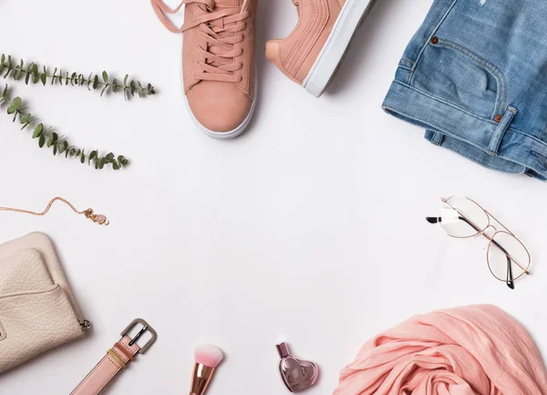 Flat lay with pink sneakers, scarf and other accessories.