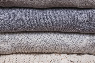 Bir sürü kalın kazak örülmüş, farklı örgü desenleri yığılmış.