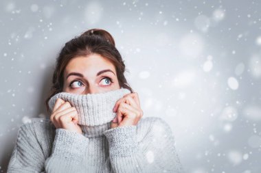 Sıcak, rahat süveter giyen mutlu genç kadın hayal kuruyor, zirveye bakıyor..