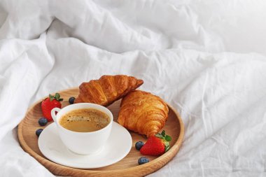Kahve ve kruvasan üzerinde beyaz bedsheets yakın çekim