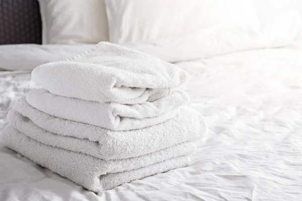 Toalhas brancas limpas na cama branca — Fotografia de Stock