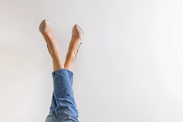 Vrouwelijke benen gekleed in jeans en hoge hak schoenen — Stockfoto