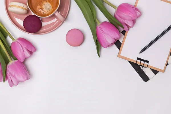 Vackra rosa tulpaner, kopp kaffe och Macarons på vita bordet — Stockfoto