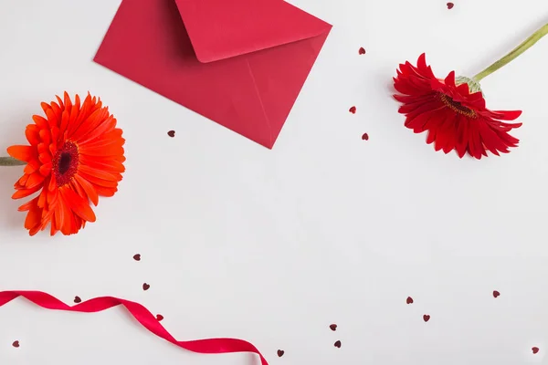 Rode bloemen, enveloppe, lint en stervormige confetti op witte achtergrond — Stockfoto