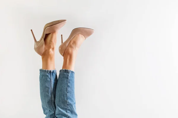 Pernas com saltos altos contra um fundo branco — Fotografia de Stock