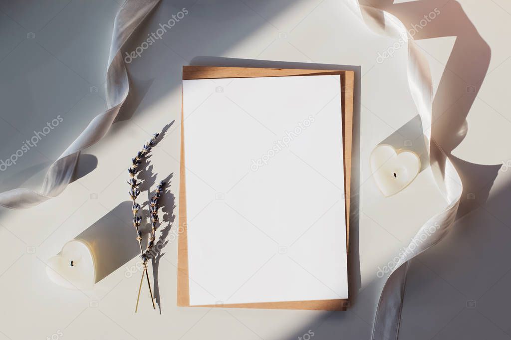 Blank paper mock-up on the table with white ribbon, lavender and heart shaped candles