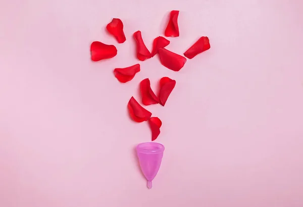 Frauenzeitkonzept. Menstruationstasse und rote Rosenblätter symbolisieren Blut. — Stockfoto