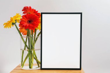 Beyaz çerçeve ve bir demet parlak Gerbera çiçeği