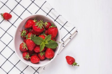 beyaz ahşap masada bir kase taze olgun çilek