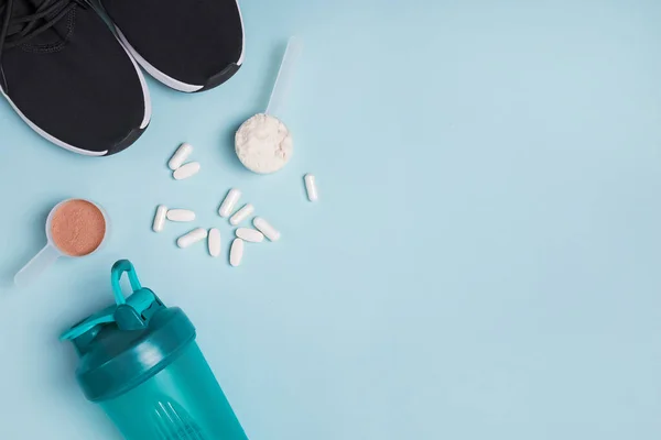 Polvo de proteína en una cuchara, coctelera, zapatillas de deporte y suplemento deportivo de dieta . —  Fotos de Stock