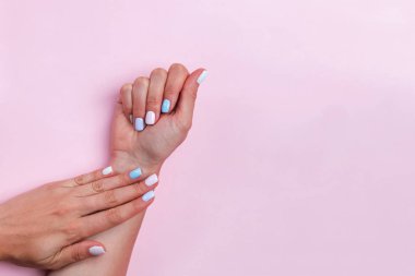 Kadın elleri pembe masanın üzerinde Güzel bir manikür gösteriyor