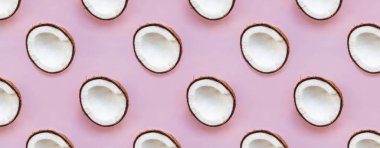 Pembe arka planda hindistan cevizi yarıları.