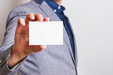 Man holding white blank paper card close-up