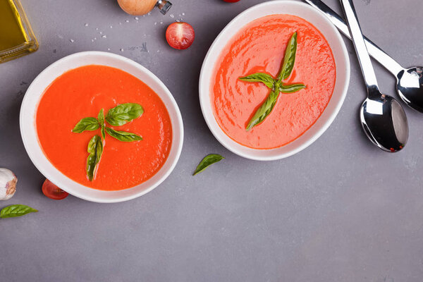 Tomato soup in bowls on gray stone table