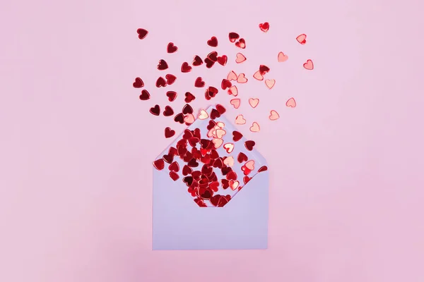 Small red shiny hearts with envelope on pink background — Stock Photo, Image