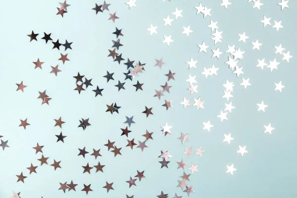 Star shaped silver sequins over blue background. — Stock Photo, Image