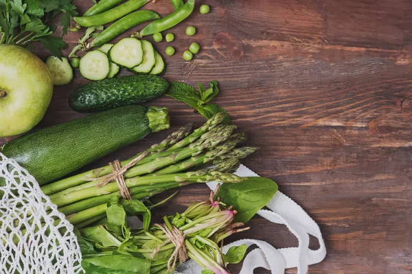 Zelenina z farmářského trhu v sáčku na opětovné použití na dřevěném pozadí — Stock fotografie