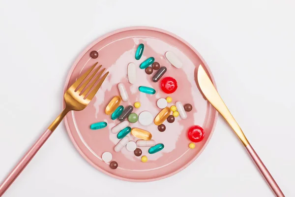 En tallrik full med kapslar och tabletter i olika former och storlekar — Stockfoto