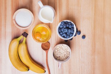 Ahşap masa üzerinde yaban mersini kekler hazırlık için Malzemeler, üst görünümü.