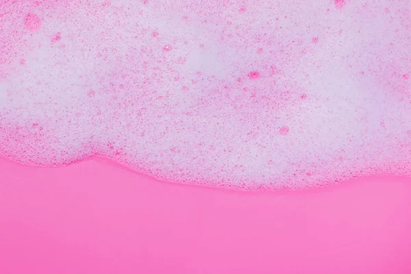 Schiuma bianca con bolle su sfondo rosa — Foto Stock