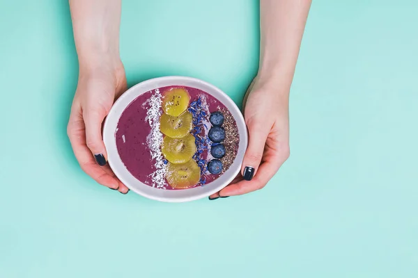 Mãos das mulheres segurando açaí tigela de smoothie berry — Fotografia de Stock