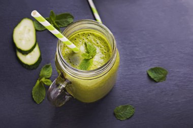 Siyah masadaki cam kavanozdaki sağlıklı yeşil smoothie..