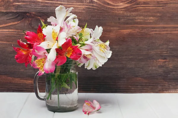 Alstromeria květiny ve skleněné sklenici — Stock fotografie