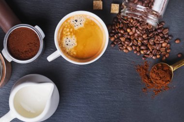 Sade kahve, espresso makinesinin filtresi ve dağınık kahve çekirdekleri.